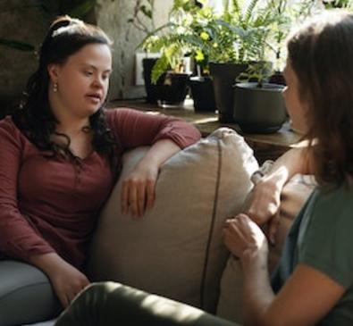 Two women sitting on couch and communicating