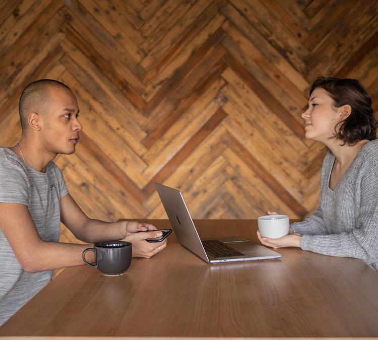 two people discussing over coffee