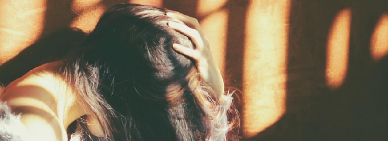 Woman holding head - Photo by Валерия on Unsplash