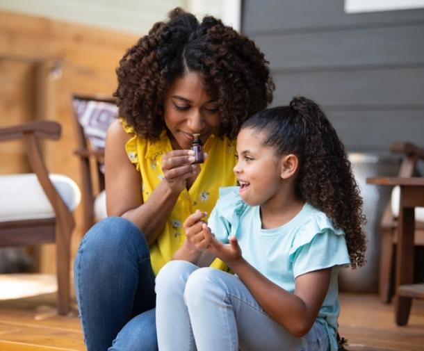 mother and daughter inhaling essential oils