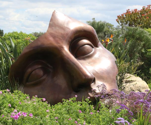 statue of a fragmented face in a garden